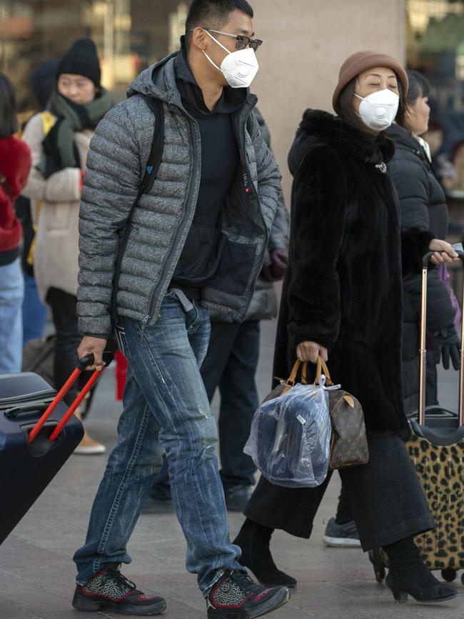 Travellers wear face masks outside the Beijing Railway Station. Picture: AP.