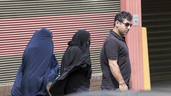 A number of people, believed to be the family of Farhad Khalil Mohammad Jabar walk out of the back entrance of the Glebe coroners court.