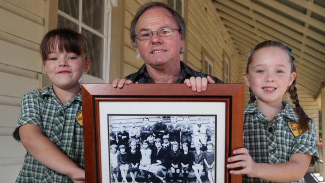 Fairfield West Public School is turning 90. Robert Crompton who's uncles came to the school when it started at one of the original buildings with his granddaughters Tiahney Berry, 5 (left) and Ella Portelli, 6 who are both in year 1 at the school with a 1920's school photo. Picture: Jonathan Ng