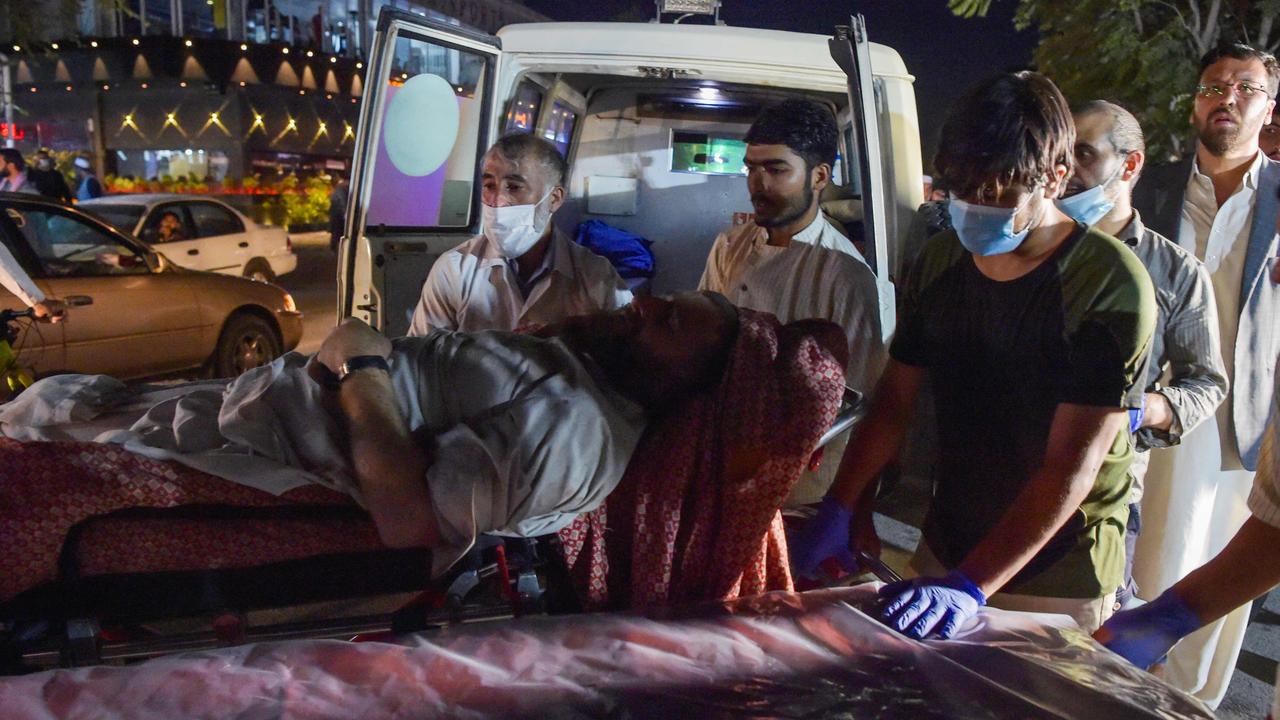 Volunteers and medical staff bring an injured man for treatment after two powerful explosions outside the airport in Kabul. Picture: Wakil Kohsar/AFP