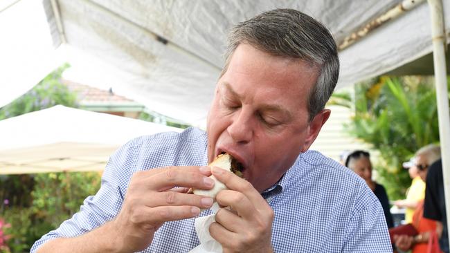 Then opposition leader Tim Nicholls eats a sausage on bread after voting at St John’s Church in Hendra in his electorate of Clayfield on the final day of the 2017 Queensland election campaign. Picture: Tracey Nearmy