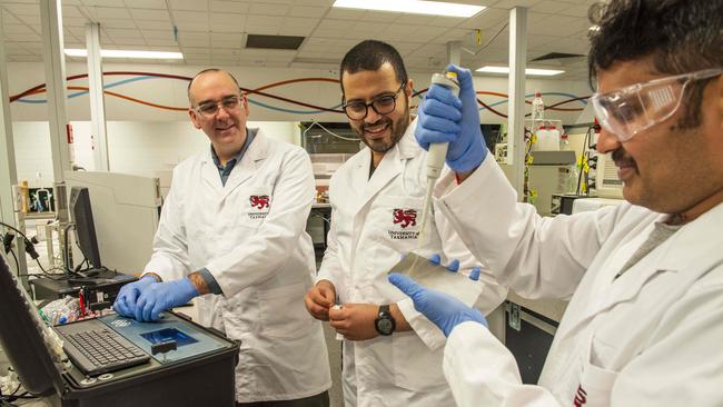 Michael Breadmore, left, with researchers Mostafa Atia, centre, and Pavan Kumar Chadalawada taking a swab to test for influenza on their converted bomb-detection device at the University of Tasmania. Picture: Chris Crerar