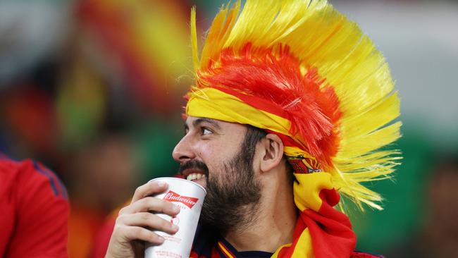 A fan takes a drink from a Budweiser cup.