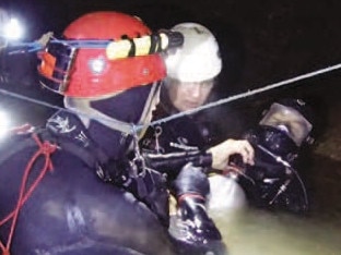 One of the Thai cave boys with his full mask on supported by members of the cave diving team including Chris Jewell, Rick Stanton and John Volanthen. Picture: Richard Harris.