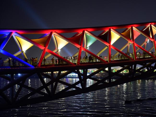 Visitors throng the illuminated Atal Pedestrian Bridge over Sabarmati River in Ahmedabad. Picture: AFP