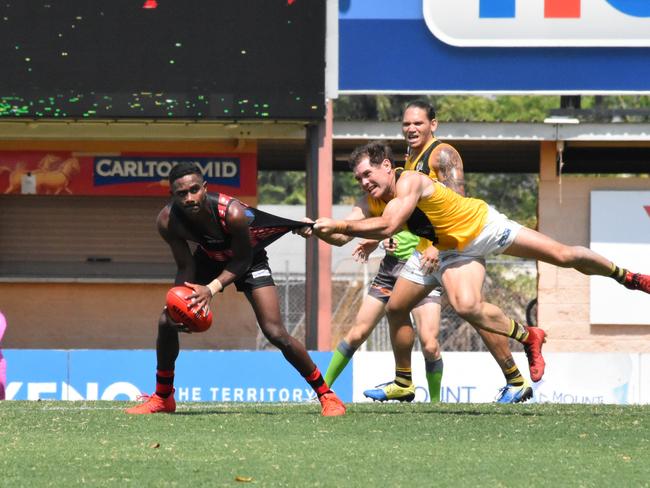 Jeffrey Simon gets set to fire out a handpass despite the close attention of Nightcliff's Brodie Filo. Picture: Tymunna Clements, AFLNT Media.