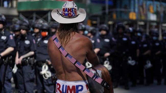 Street performer Robert John Burck, better known as the Naked Cowboy, looks on at police in Times Square, Manhattan. Picture: AFP