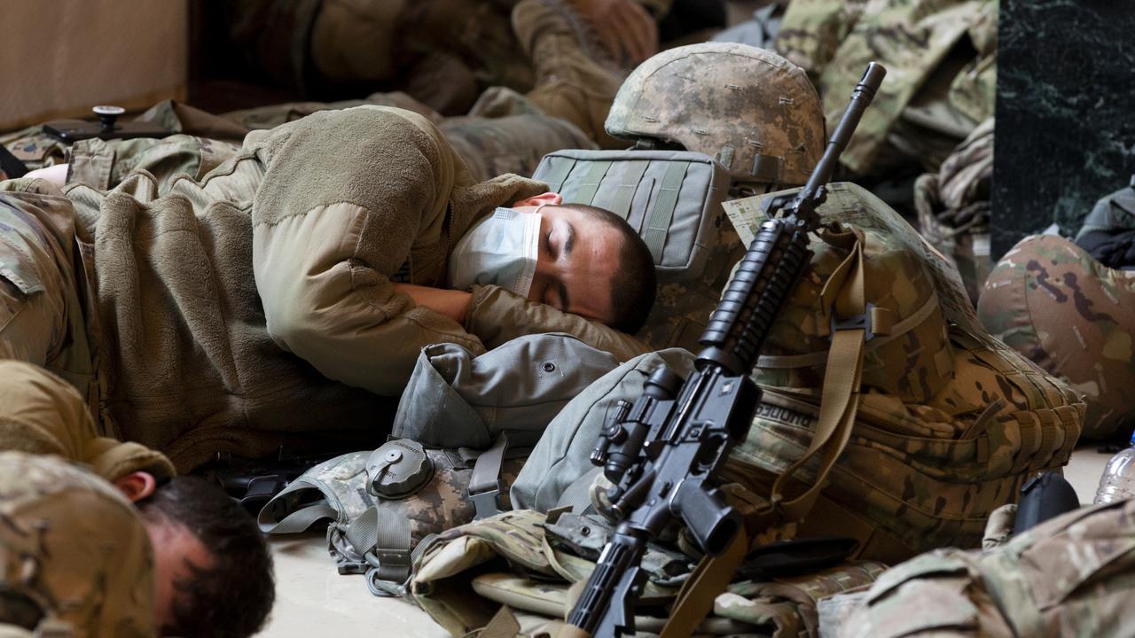 US National Guard troops rest on the floor of the Capitol building. Picture: Michael Reynolds/EPA/AAP