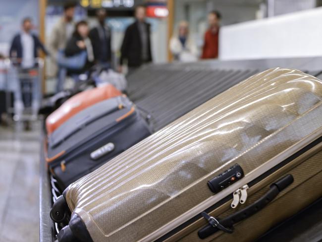 Business people standing at baggage claim in airport.