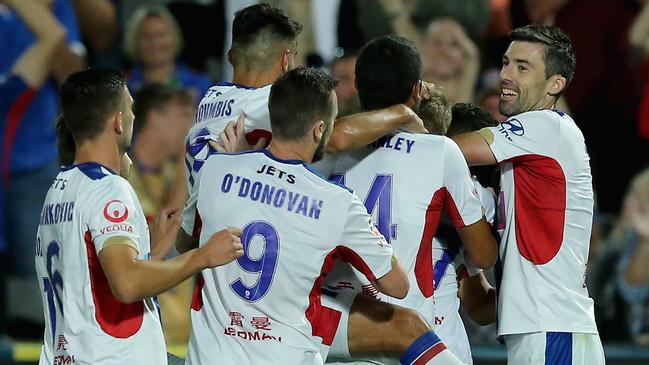 Newcastle Jets players celebrate their eighth and final goal against the Mariners on Saturday night.