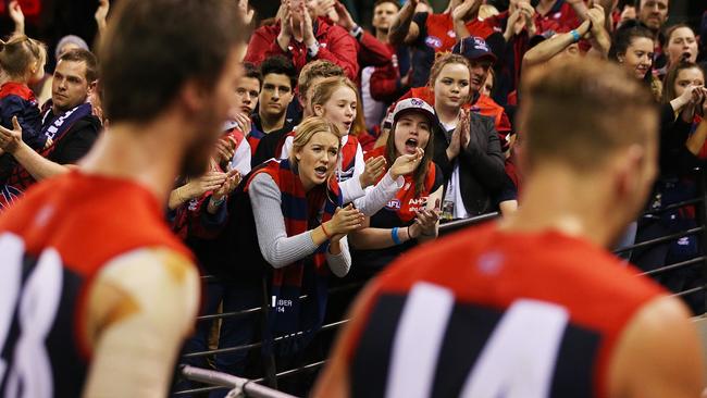 Melbourne players are cheered off by their fans.