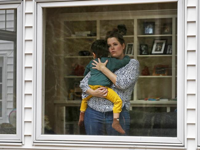 In this Wednesday, April 1, 2020 photo, Joy Engel holds her son at her home in Cape Elizabeth, Maine. Engel, who is pregnant, and her husband, Dr. Ben Hagopian, who works at a family practice and an urgent care clinic, decided to isolate themselves from each since the coronavirus outbreak. (AP Photo/Robert F. Bukaty)