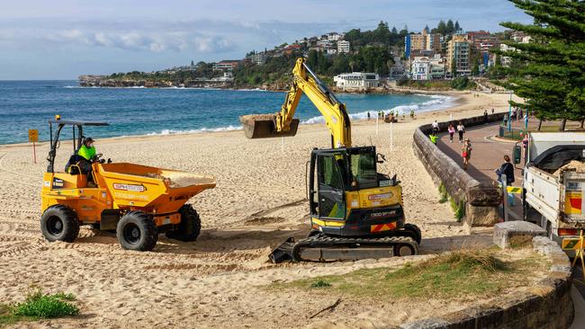 Workers clean up Coogee Beach on Wednesday. Picture: Justin Lloyd