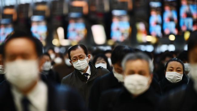 Mask-clad commuters make their way to work during morning rush hour at the Shinagawa train station in Tokyo. Picture: Charly Triballeau/ AFP.