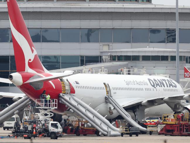 Workers inspecting QF575 after the Qantas flight bound for Perth has had to turn back shortly after takeoff from Sydney airport this morning as pungent fumes filling the cabin. The Airbus A330 was forced to make an emergency landing and the emergency slides were deployed for passengers to disembark at the Sydney Domestic Airport Terminal 3. Picture: Jonathan Ng