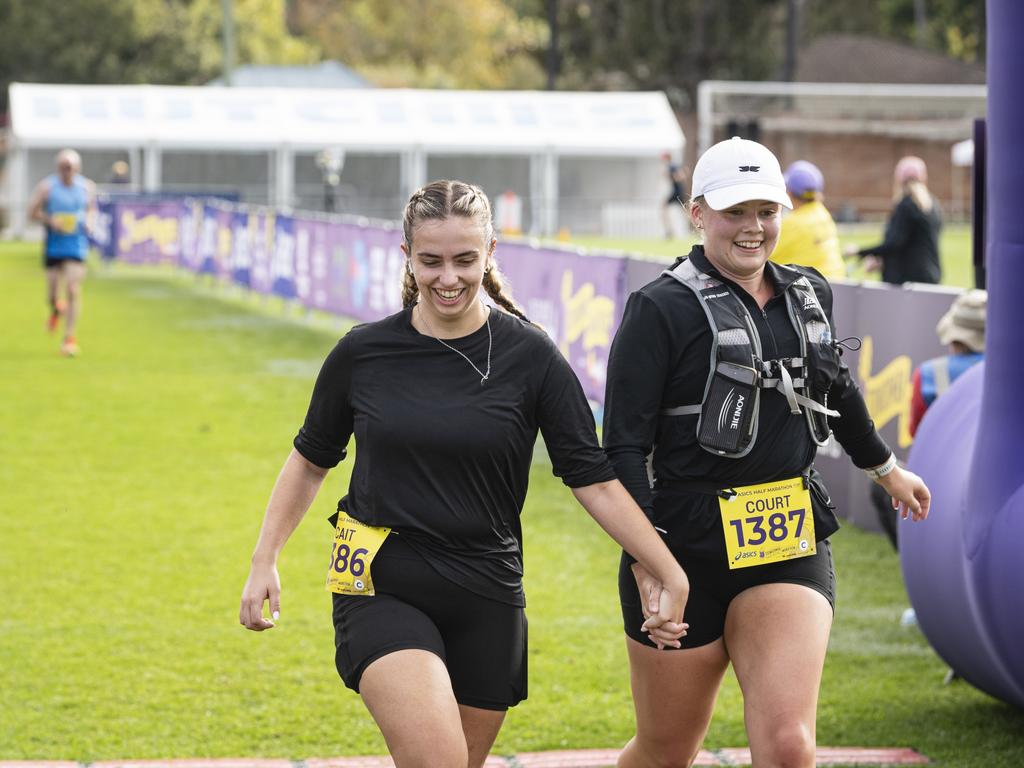 Runners hold hands as they finish the half marathon together in the Toowoomba Marathon event, Sunday, May 5, 2024. Picture: Kevin Farmer