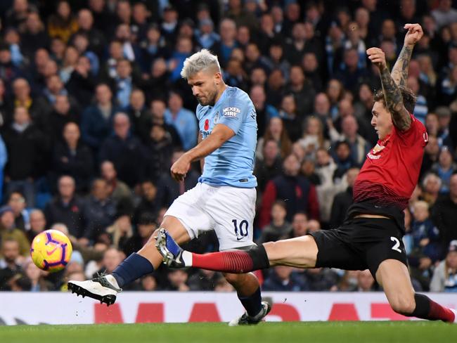 MANCHESTER, ENGLAND - NOVEMBER 11:  Sergio Aguero of Manchester City scores his team's second goal while being challenged by Victor Lindelof of Manchester United during the Premier League match between Manchester City and Manchester United at Etihad Stadium on November 11, 2018 in Manchester, United Kingdom.  (Photo by Laurence Griffiths/Getty Images)