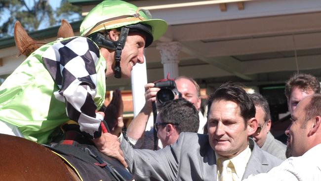 Damien Oliver and Neil Pinner (grey suit) have been friends for many years. Picture Graeme Collopy