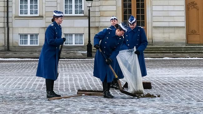 Female members of the Guard Hussar Regiment's Mounted Squadron clean the cobbled streets outside Frederik VIII’s palace at Amalienborg. Picture: Jacquelin Magnay.