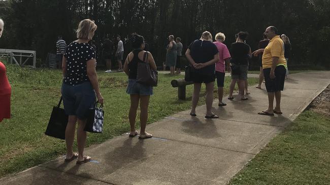 A man directs the crowd to stay on the lines.