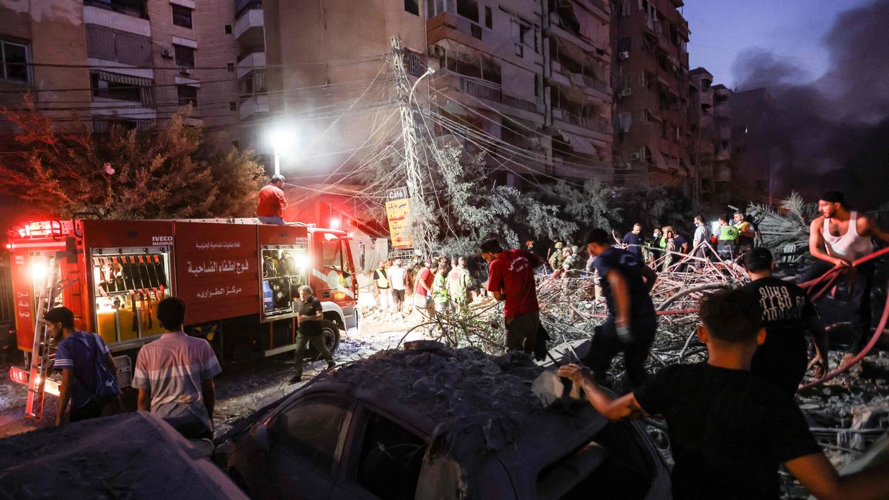 People and firefighters gather at the scene of Israeli air strikes. (Photo by Ibrahim AMRO / AFP)