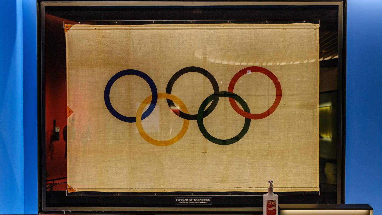 A bottle of hand sanitiser next to a Tokyo 1964 Olympic Games flag at the Japan Olympic Museum in Tokyo, is a sign of what’s to come with a COVID Games. Photo Philip FONG / AFP