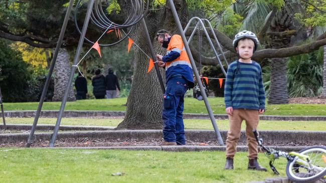 A worker fences off play equipment in St Kilda Botanical Gardens. Picture: Jason Edwards