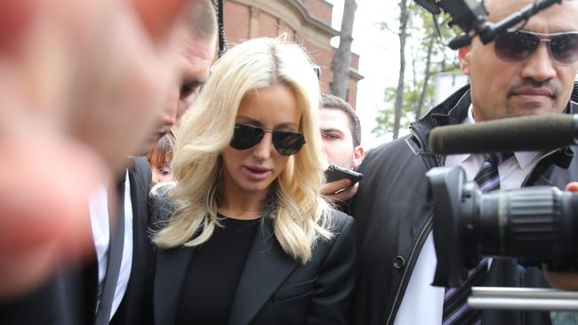 Security guards help clear a path for Roxy Jacenko after her husband Oliver Curtis was jailed for a year. Picture: John Grainger