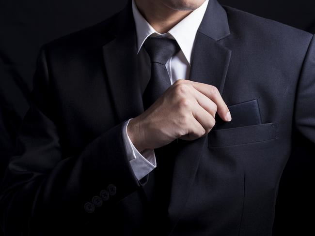 Businessman taking smartphone out of suit pocket generic.