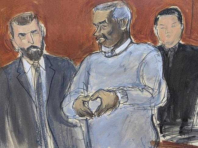 Combs, centre, motions a heart sign to his family in court. Picture: Elizabeth Williams via AP