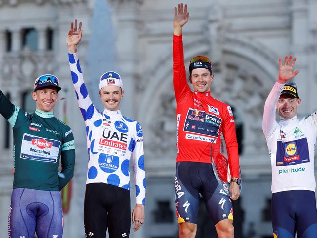 (From L) Team Alpecin's Kaden Groves, Team UAE's Jay Vine celebrates, overall leader Team Bora's Primoz Roglic and Team Lidl-Trek's Mattias Skjelmose celebrate on the podium after the last stage of the Vuelta a Espana, a 24,6 km time-trial race between Madrid and Madrid, on September 8, 2024. (Photo by OSCAR DEL POZO / AFP)