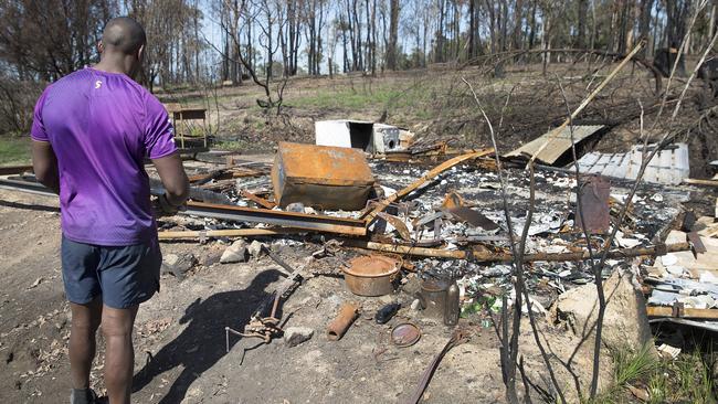 Isaac Lumelume examines what remains of a burnt out shed.