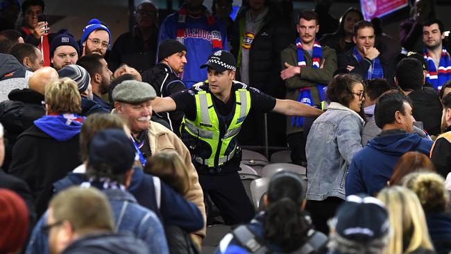 A police officer separates fans during a Carlton and Western Bulldogs clash at Marvel Stadium in June. Picture: Getty