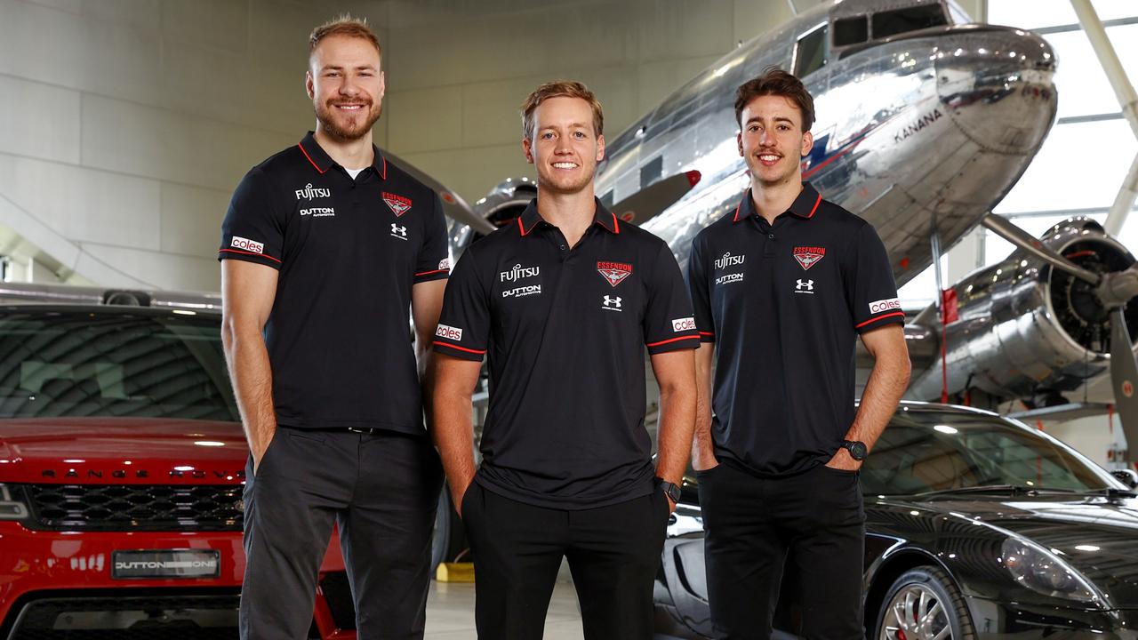 Ben McKay (left) in his new club colours with Darcy Parish (centre) and Nic Martin at Essendon’s sponsorship announcement with Dutton Automotive on Monday. Picture: Michael Klein