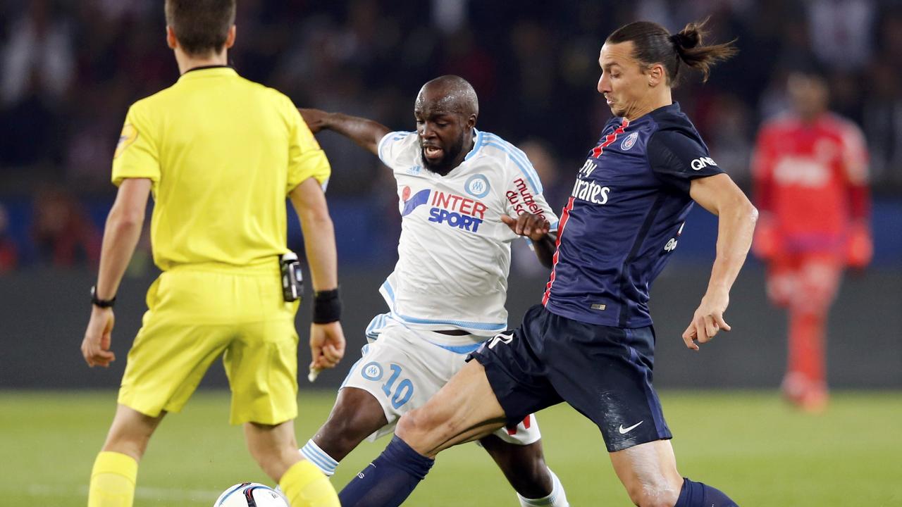 Paris St Germain's Zlatan Ibrahimovic (R) challenges Olympique Marseille's Lassana Diarra (C) as referee Benoit Bastien (L) looks on during their French Ligue 1 soccer match at the Parc des Princes stadium in Paris, France, October 4, 2015. REUTERS/Regis Duvignau