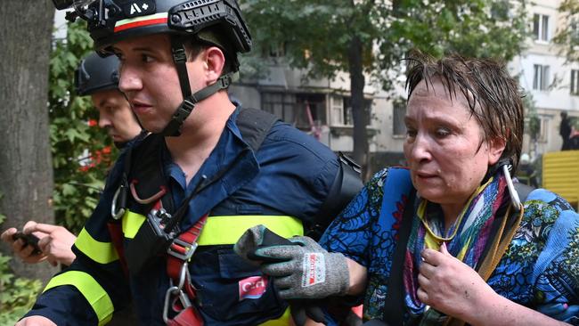 Ukrainian rescuers help an injured woman to leave the site of a missile attack in Kharkiv on August 30. Picture: AFP