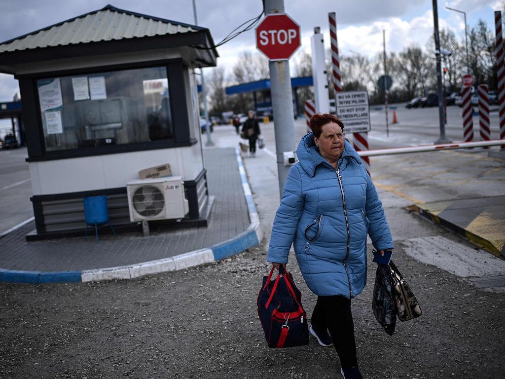 An Ukrainian refugee carries her luggage as she crosses the Ukrainian-Moldovan border into Moldova at the Palanca border crossing. Picture: AFP