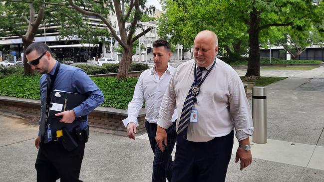 Ben Aulich (centre) arrives at the Canberra watch house with detectives, following his arrest in relation to alleged money laundering. Picture: Craig Dunlop