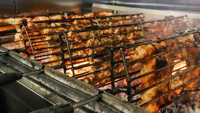 Butterflied whole chickens cooking over hot charcoal. Picture: Jenifer Jagielski