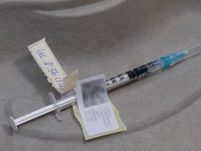 FRANKFURT AM MAIN, GERMANY - JANUARY 19: A prepared syringe with the Biontech-Pfizer vaccine is brought into a vaccination booth on January 19, 2021 in Frankfurt am Main, Germany. The State of Hesse is operating one of its vaccination centers, where thousands of people would otherwise come together at concerts and trade fairs. On the first day of regular operation, around 500 people are to be vaccinated against Covid-19. (Photo by Boris Roessler - Pool /Getty Images)