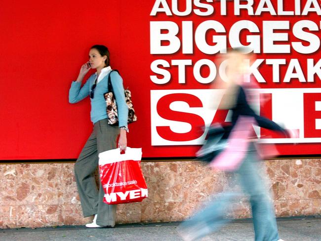 Generic of woman shopper with Myer stocktake sale shopping bag, walking past the Myer, Mall, department store in Brisbane, during end of financial year sale.