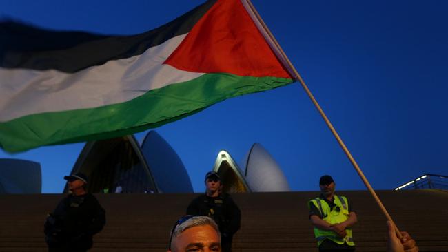 A Palestine supporter waves a flag during a rally outside the Sydney Opera House on October 9. Picture: Lisa Maree Williams