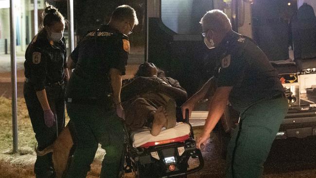 A patient’s dog tries to join her on the stretcher after she collapsed at an Alice Springs payphone. Picture: Liam Mendes/The Australian