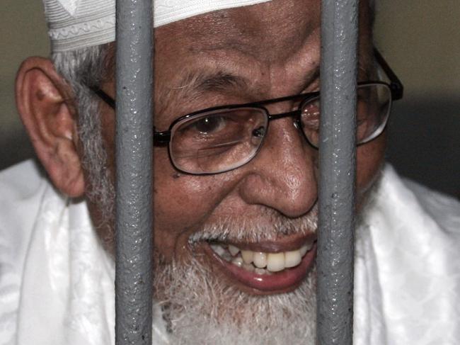 Radical cleric Abu Bakar Bashir talks to reporters from behind bars before the start of his trial at a district court in Jakarta, Indonesia, Thursday, June 16, 2011. Indonesia's capital will be secured by more than 3,000 police and soldiers for the verdict Thursday in the terrorism trial of Bashir, officials said. (AP Photo/Irwin Ferdiansyah)