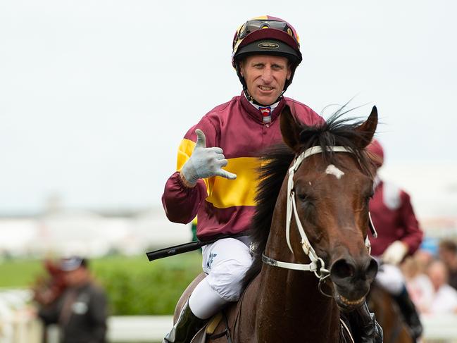 Jockey Dale Smith gestures after riding Magnufighter to victory in race 2, the Open Quality Handicap, during Doomben Raceday at the Doomben Racecourse in Brisbane, Saturday, December 15, 2018. (AAP Image/Albert Perez)