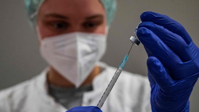 A health worker prepares a syringe with the Comirnaty Covid-19 vaccine by Biontech-Pfizer at a vaccination centre in Berlin's Humborldt Forum museum on January 18, 2022. (Photo by John MACDOUGALL / AFP)