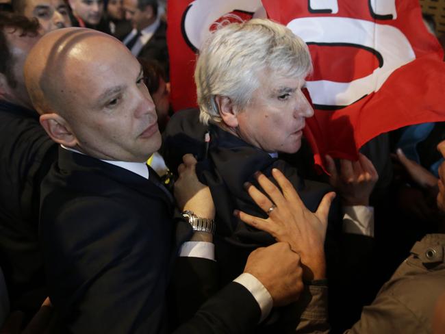 Whisked away ... Air France executive Pierre Plissonnier accompanied by security officers. Picture: AFP/Kenzo Tribouillard