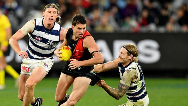 MELBOURNE, AUSTRALIA – JUNE 29: Archie Perkins of the Bombers is tackled by Tom Stewart of the Cats during the round 16 AFL match between Geelong Cats and Essendon Bombers at Melbourne Cricket Ground, on June 29, 2024, in Melbourne, Australia. (Photo by Josh Chadwick/AFL Photos/via Getty Images)