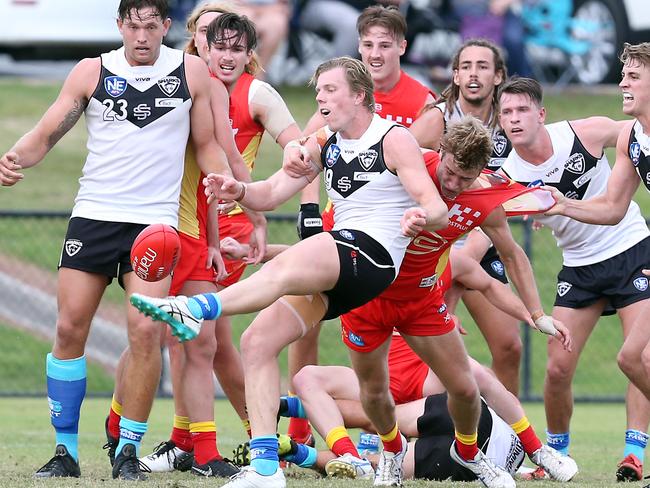 Suns player Mitch Riordan attempting to tackle Southport’s Tom Fields as he kicks for goal in the Round 11 NEAFL game between the Southport Sharks and Gold Coast Suns at Fankhauser Reserve. Picture: Richard Gosling