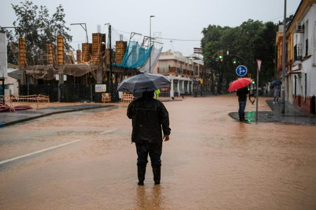 A person stands in the middle of a flooded street in Campanillas, near Malaga, on November 13, 2024